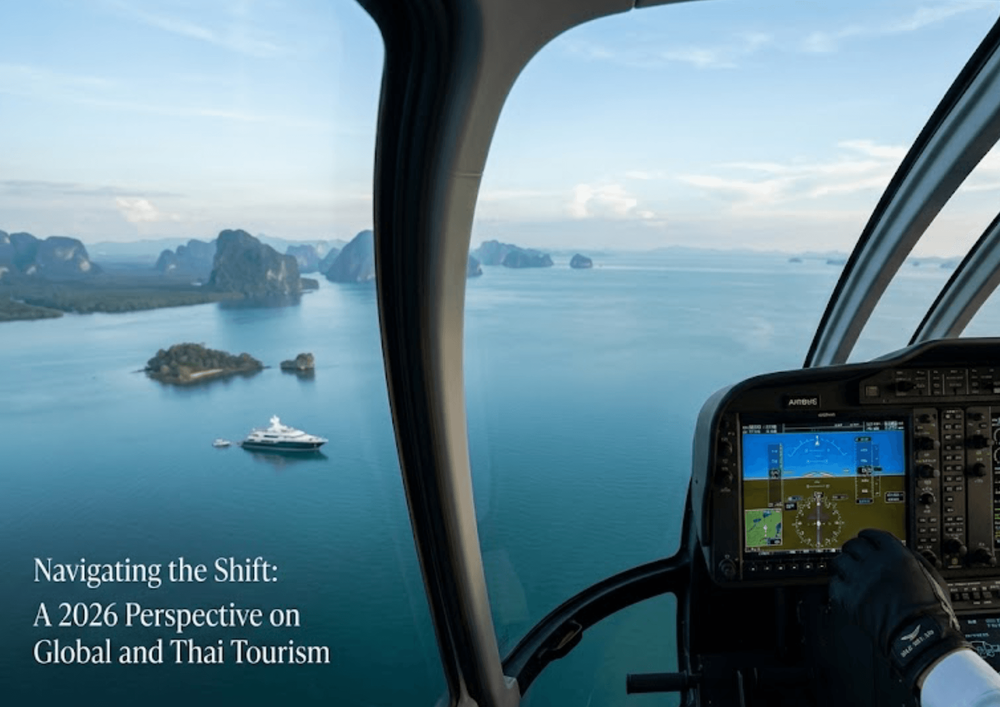 มุมมองจากห้องนักบินเฮลิคอปเตอร์ Airbus ของ Silk Sky Air เหนืออ่าวพังงา พร้อมแผงควบคุมของนักบินในเบื้องหน้า เรือยอร์ชหรูลำใหญ่บนน้ำสีฟ้าเทอควอยซ์ และเกาะหินปูนที่ทอดยาวสุดสายตา — ภาพหลักสำหรับบทความมุมมองการท่องเที่ยวโลกและไทยปี 2569